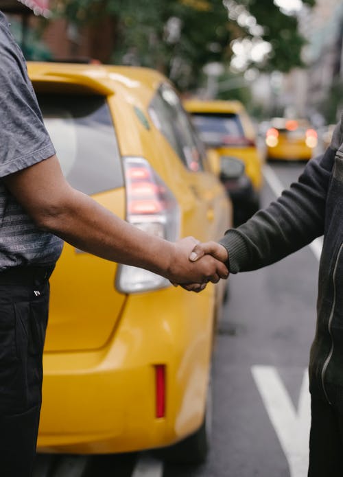 族裔男子握手站在出租车附近 · 免费素材图片