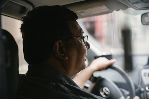 男子在城市道路上驾驶汽车 · 免费素材图片