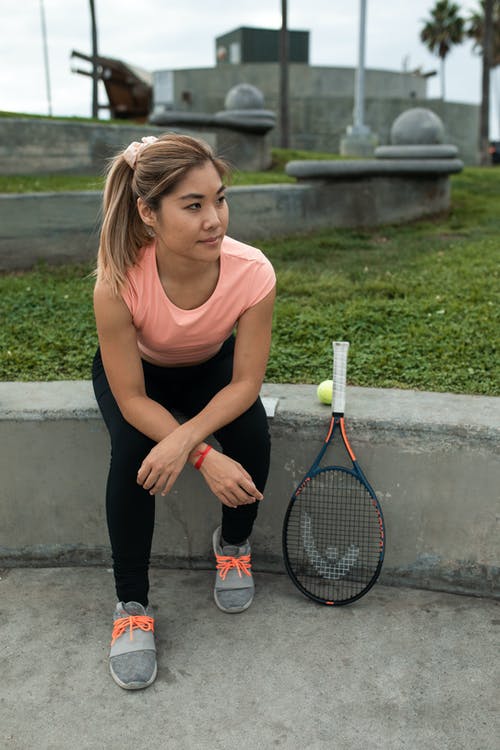 棕色背心和黑色紧身裤，拿着网球拍的女人 · 免费素材图片