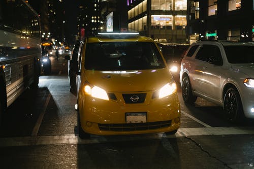 闪亮的出租车和夜间城市街道上行驶的汽车 · 免费素材图片