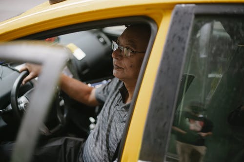 黄色汽车方向盘的中年驾驶员 · 免费素材图片