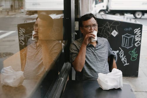体贴的民族男子在街边咖啡馆喝咖啡 · 免费素材图片