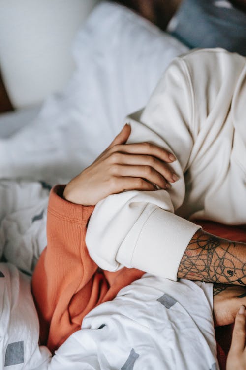 作物族裔女人拥抱同性恋纹身爱在床上 · 免费素材图片
