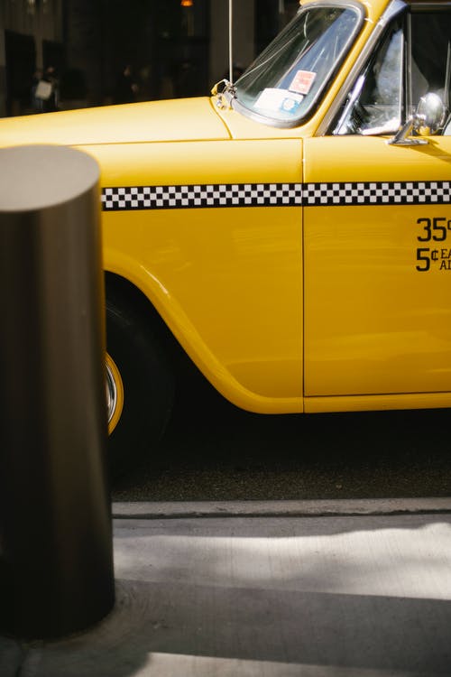 沿巷道行驶的黄色现代出租车 · 免费素材图片