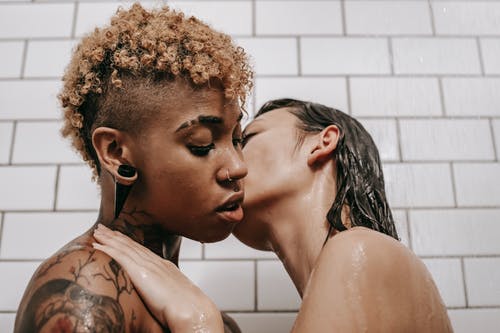 多民族的脱下衣服的女性情侣接吻在淋浴下 · 免费素材图片