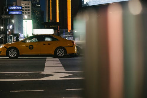 晚上在城市街道上驾驶的当代出租车 · 免费素材图片