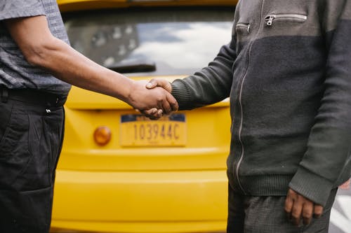 民族男子在出租车附近握手 · 免费素材图片