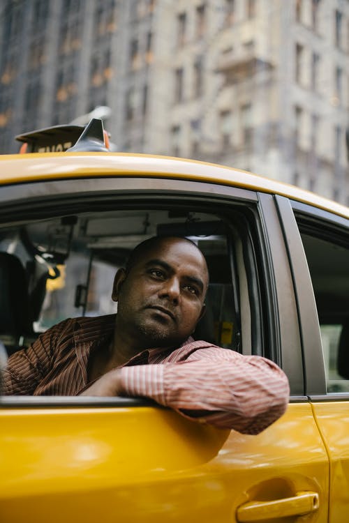 坐在黄色车内的黑色和白色条纹衬衫的男人 · 免费素材图片