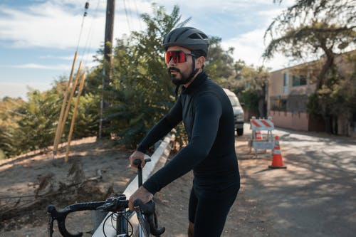 黑色长袖衬衫和黑色的裤子，骑自行车的人 · 免费素材图片