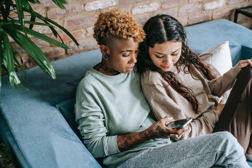 聚焦女同性恋夫妇与智能手机在沙发上 · 免费素材图片