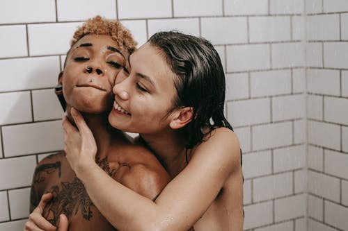 爱亚洲女人在淋浴中拥抱裸体黑人女友 · 免费素材图片