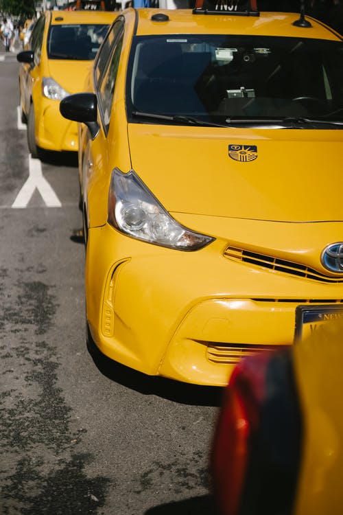 沥青路面上的多彩豪华出租车汽车 · 免费素材图片