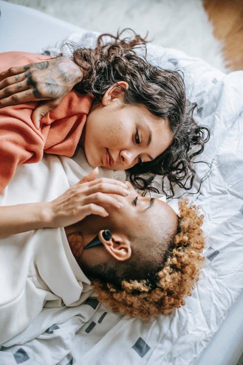 浪漫多样的女同性恋夫妇在舒适的床上拥抱 · 免费素材图片