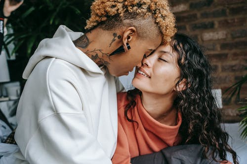 浪漫多种族女同性恋夫妇在沙发上拥抱 · 免费素材图片