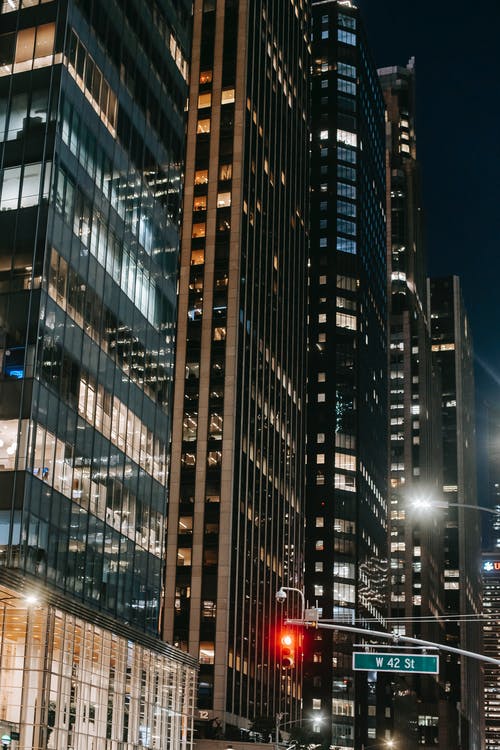 晚上排在繁忙的城市街道上的摩天大楼 · 免费素材图片