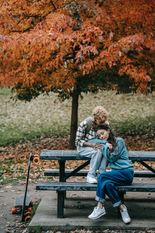 男人和女人坐在棕色的木凳上 · 免费素材图片