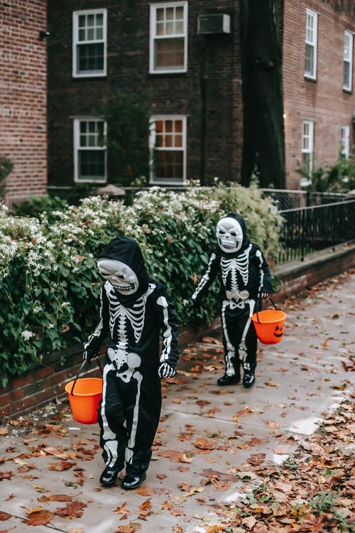 拿着橙色塑料桶的黑白服装的人 · 免费素材图片