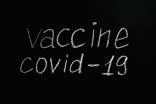 在黑色背景上的疫苗covid 19刻字文本 · 免费素材图片