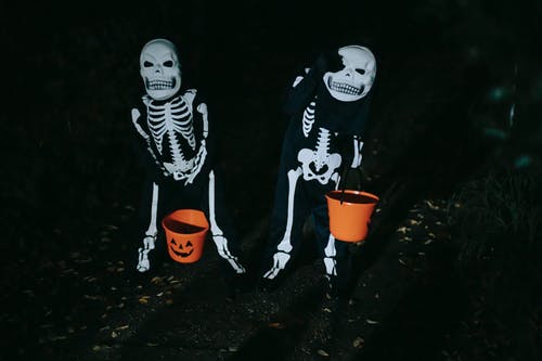 2名身穿黑色和白色熊猫服装的男子站在橙色桶旁边 · 免费素材图片