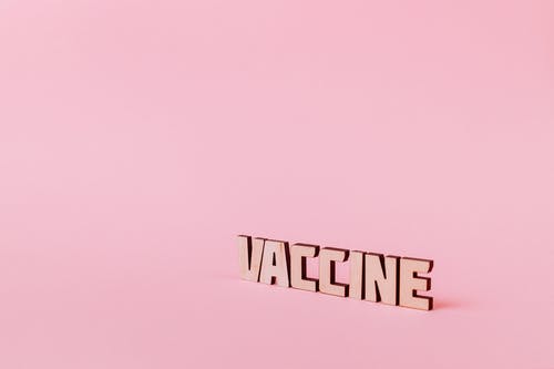 疫苗文本在粉红色的背景上 · 免费素材图片