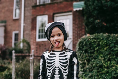 黑色和白色条纹长袖衬衫站在棕色砖建筑附近的女人 · 免费素材图片