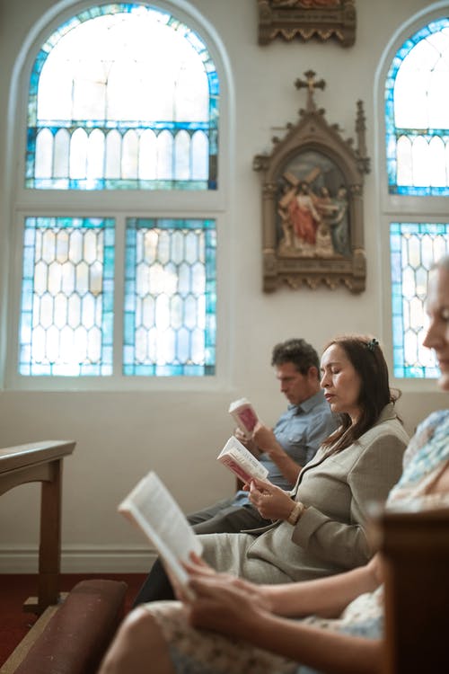 男人和女人坐在椅子上看书 · 免费素材图片