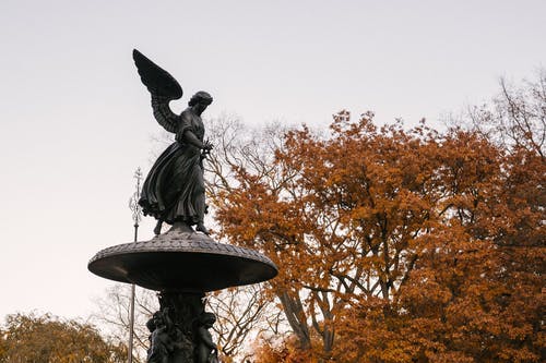 水天使雕像反对秋天的树木 · 免费素材图片