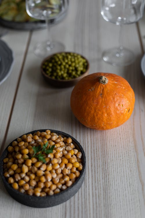 桌上的绿色圆形水果旁边的橙色水果 · 免费素材图片