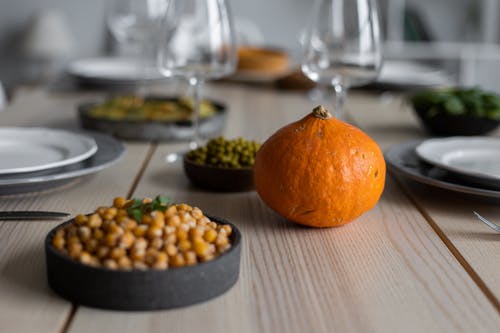 在棕色木制的桌子上的黑色圆形板旁边的橙色水果 · 免费素材图片