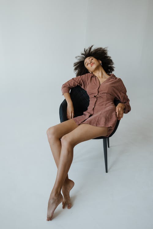 坐在椅子上的棕色长袖连衣裙的女人 · 免费素材图片