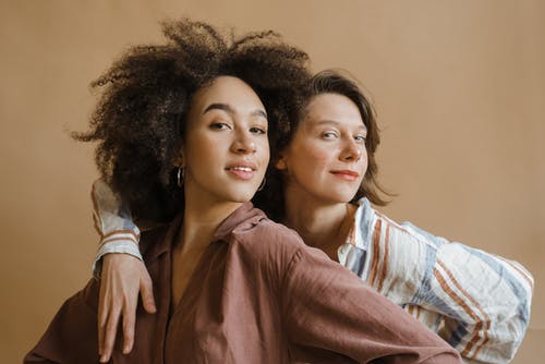 棕色长袖衬衫在白色和蓝色衬衫的女人旁边的女人 · 免费素材图片