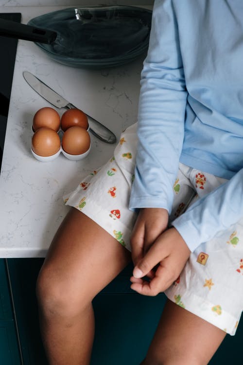 白色和黄色的花衬衫，拿着橙色水果的人 · 免费素材图片