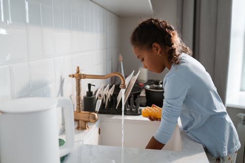 蓝色长袖衬衫洗碗的女人 · 免费素材图片