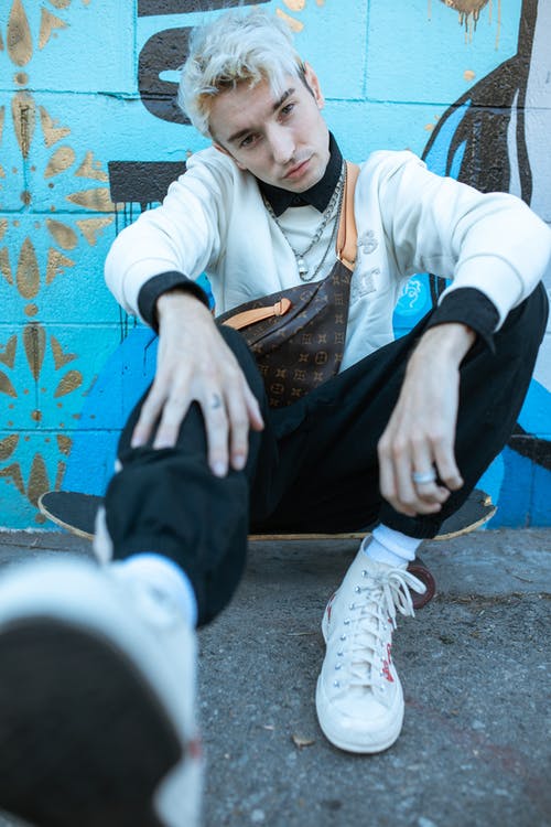 白色礼服衬衫和黑色的裤子，坐在水泥地上的男人 · 免费素材图片