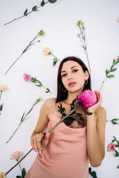 拿着粉红色花朵的粉红色背心的女人 · 免费素材图片