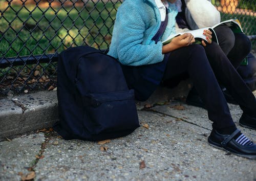 播种无法认出的女学生在公园里读教科书 · 免费素材图片