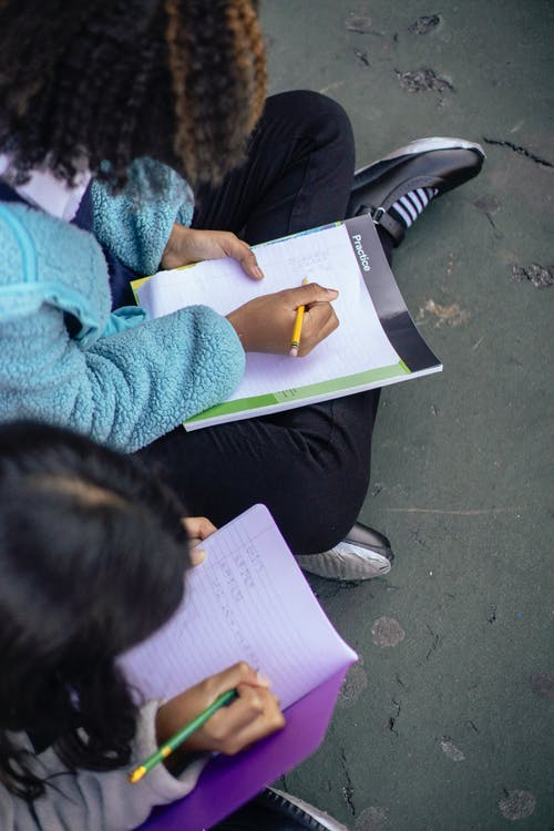 勤奋的多民族女孩写在纸上 · 免费素材图片
