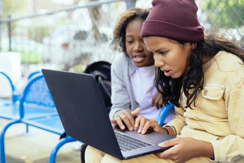 不同的女孩在院子里使用笔记本电脑 · 免费素材图片