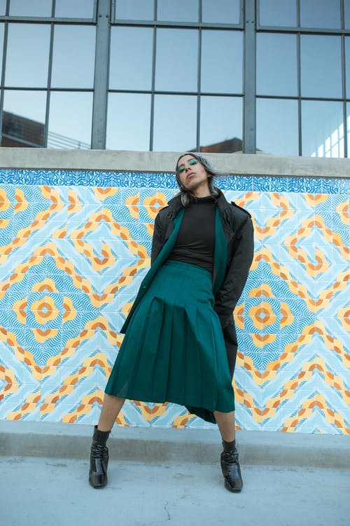 黑色和绿色的裙子，站在蓝色和棕色的水泥地板上的女人 · 免费素材图片