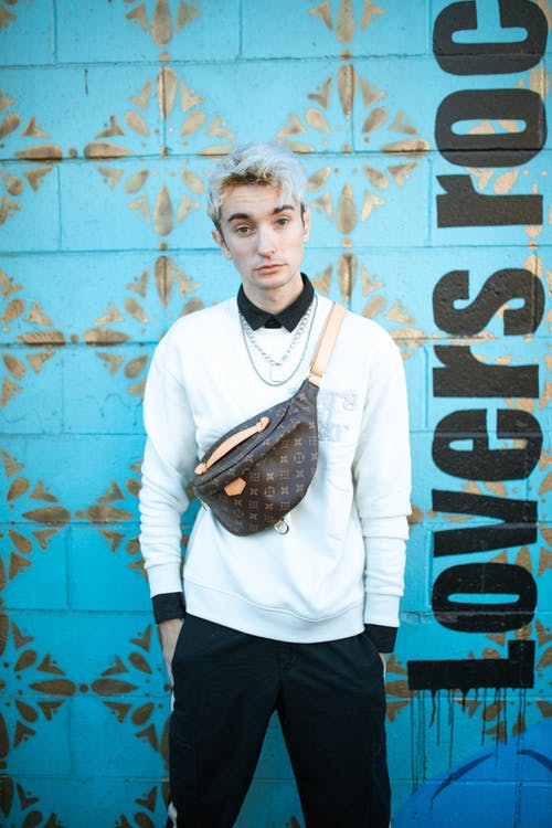 穿着白色礼服衬衫和黑色裤子的男人抱着棕色皮革吊袋 · 免费素材图片