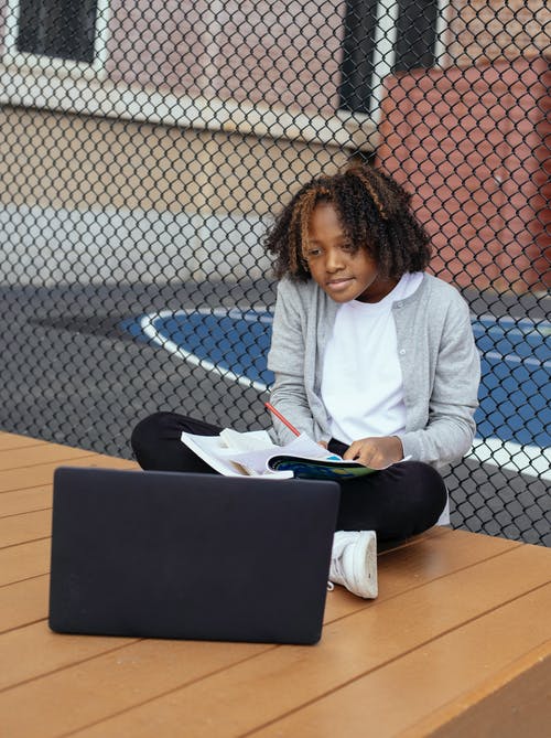 集中的非洲裔美国小学生在学习时看着工作簿的笔记本电脑 · 免费素材图片