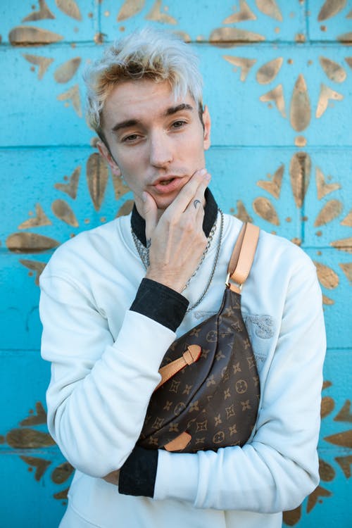 拿着黑色和棕色背包的白色长袖衬衫的女人 · 免费素材图片