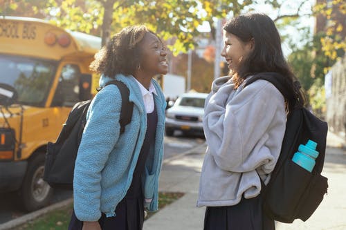 快乐多样的女学生在街上聊天和笑 · 免费素材图片