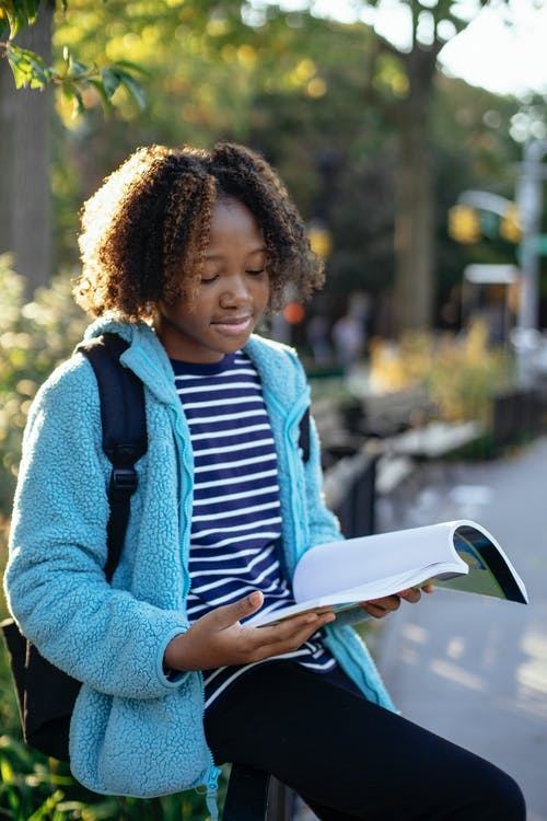 黑人女学生与工作簿在大街上学习 · 免费素材图片