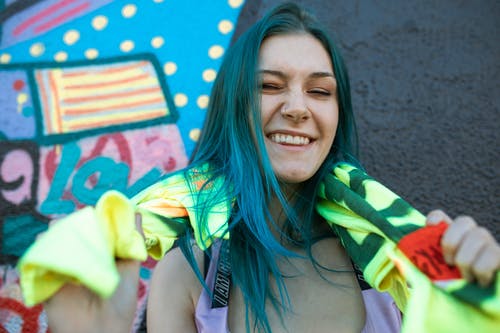 绿色和黄色围巾微笑的女人 · 免费素材图片
