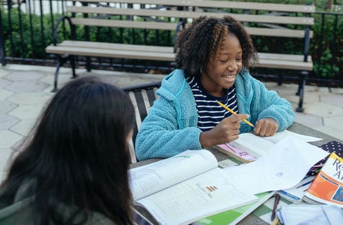 黑人女学生和同学一起做作业 · 免费素材图片