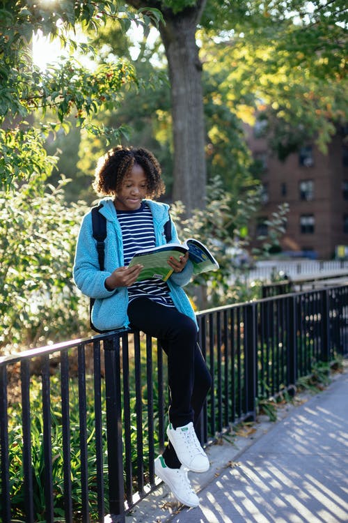 在城市公园的时尚女生阅读教科书 · 免费素材图片
