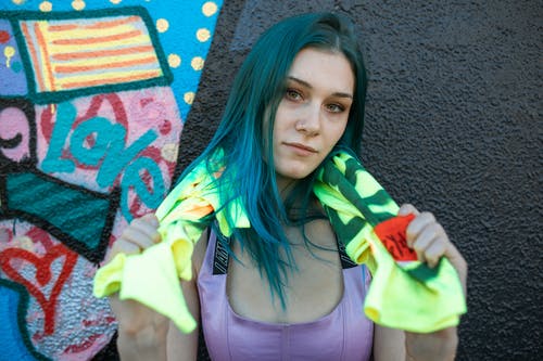 紫色背心举行绿色和黄色纺织的女人 · 免费素材图片