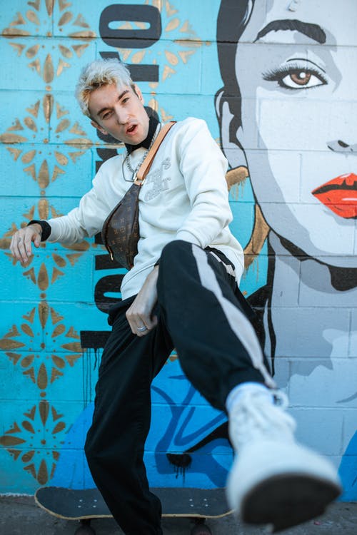 白色礼服衬衫和黑色的裤子，坐在白色和蓝色的混凝土墙上的男人 · 免费素材图片