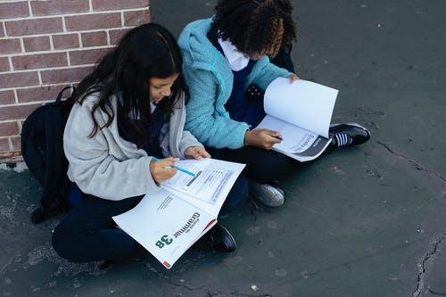 不同聪明的女孩在一起解决家庭作业与教科书 · 免费素材图片